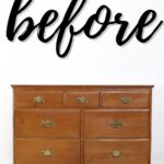 A wooden dresser with brass handles and the word before written above it in large, cursive text.
