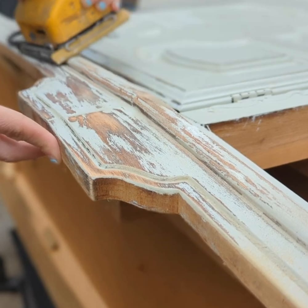 sanding paint on a buffet smooth with a sander