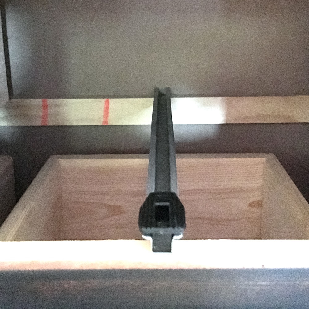 photo of furniture with drawer removed showing the metal slide and plastic stopper