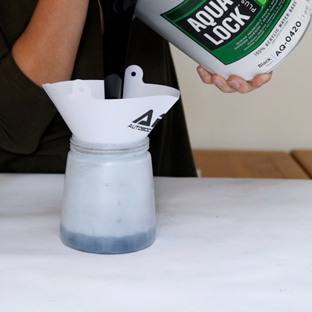 pouring aqua lock primer into sprayer's container
