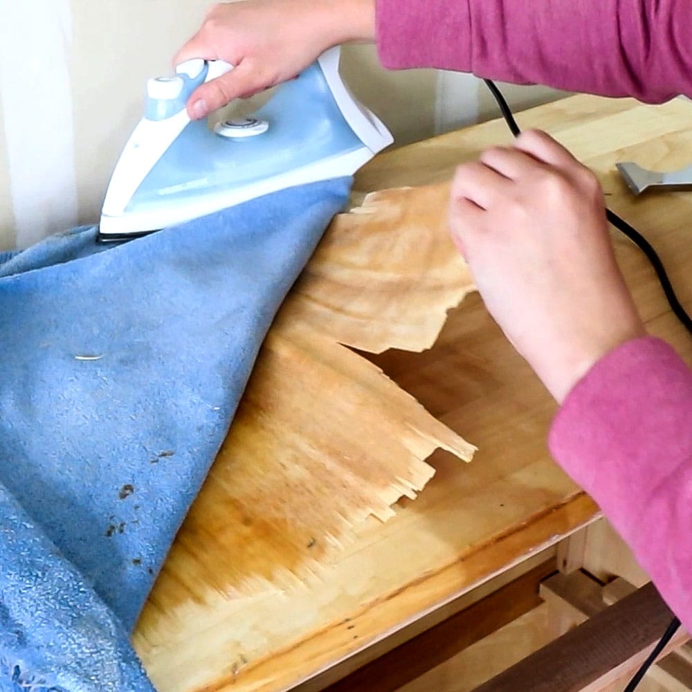 removing stucked veneer using damp towel, flat iron, and scraper
