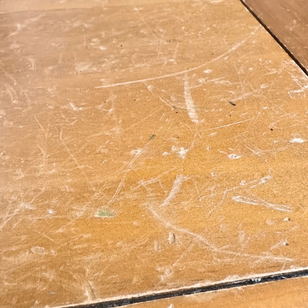 Close view of the top of a dinged and scratched end table