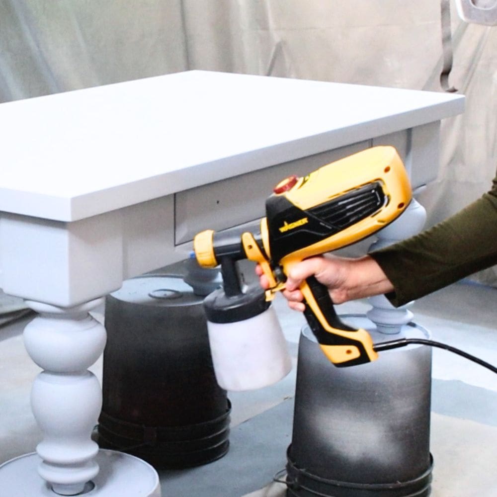applying paint onto furniture with a paint sprayer
