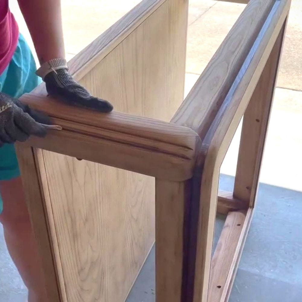 using a sanding grip to sand the crevices on the furniture