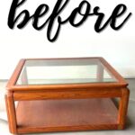 A square wooden coffee table with a glass top and the word before written above it.