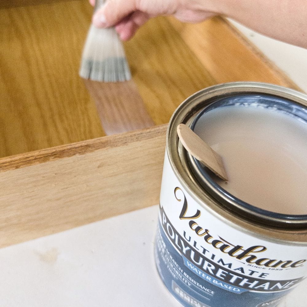 applying polyurethane with a paint brush to seal the sticky residue