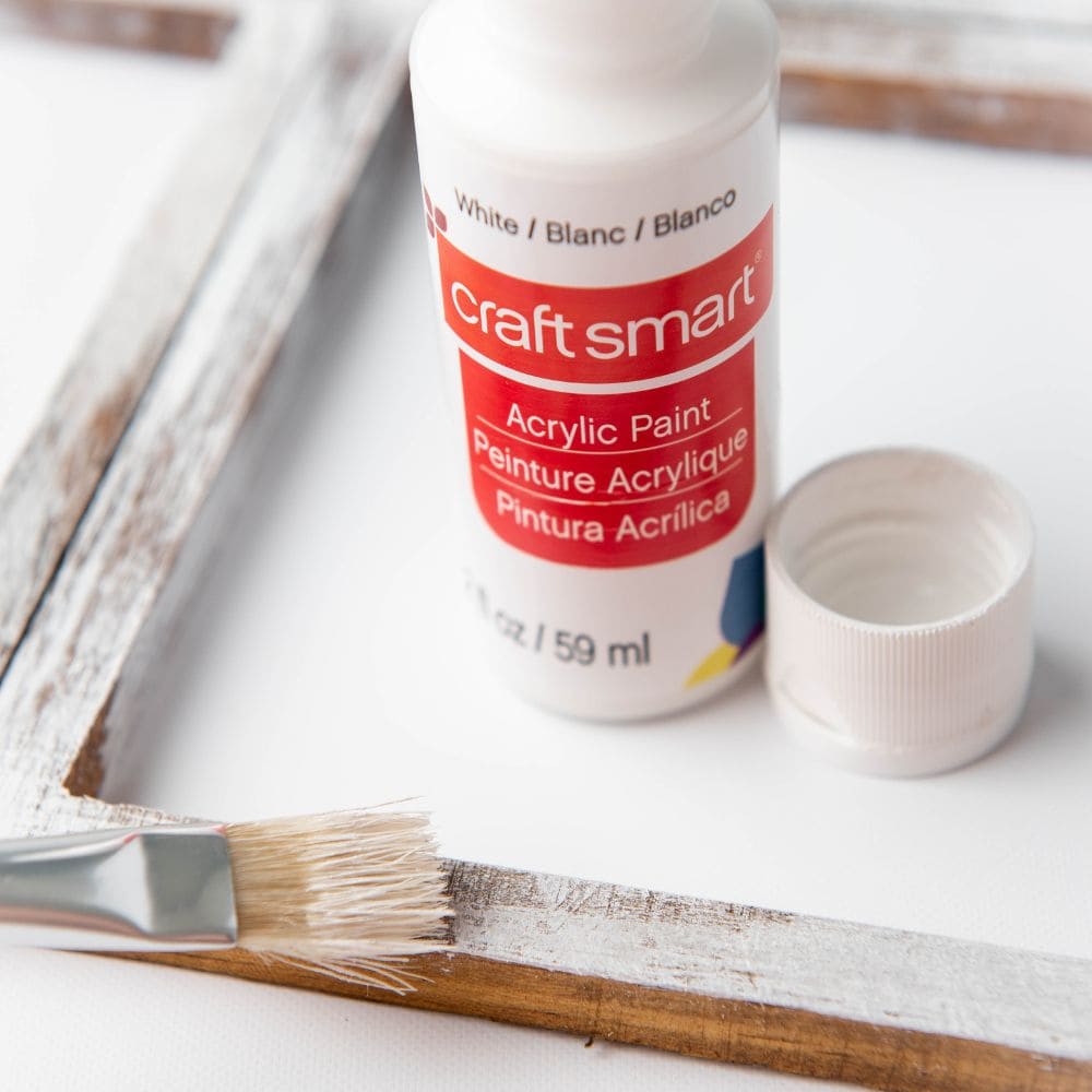 photo of applying paint onto frame with a paint brush