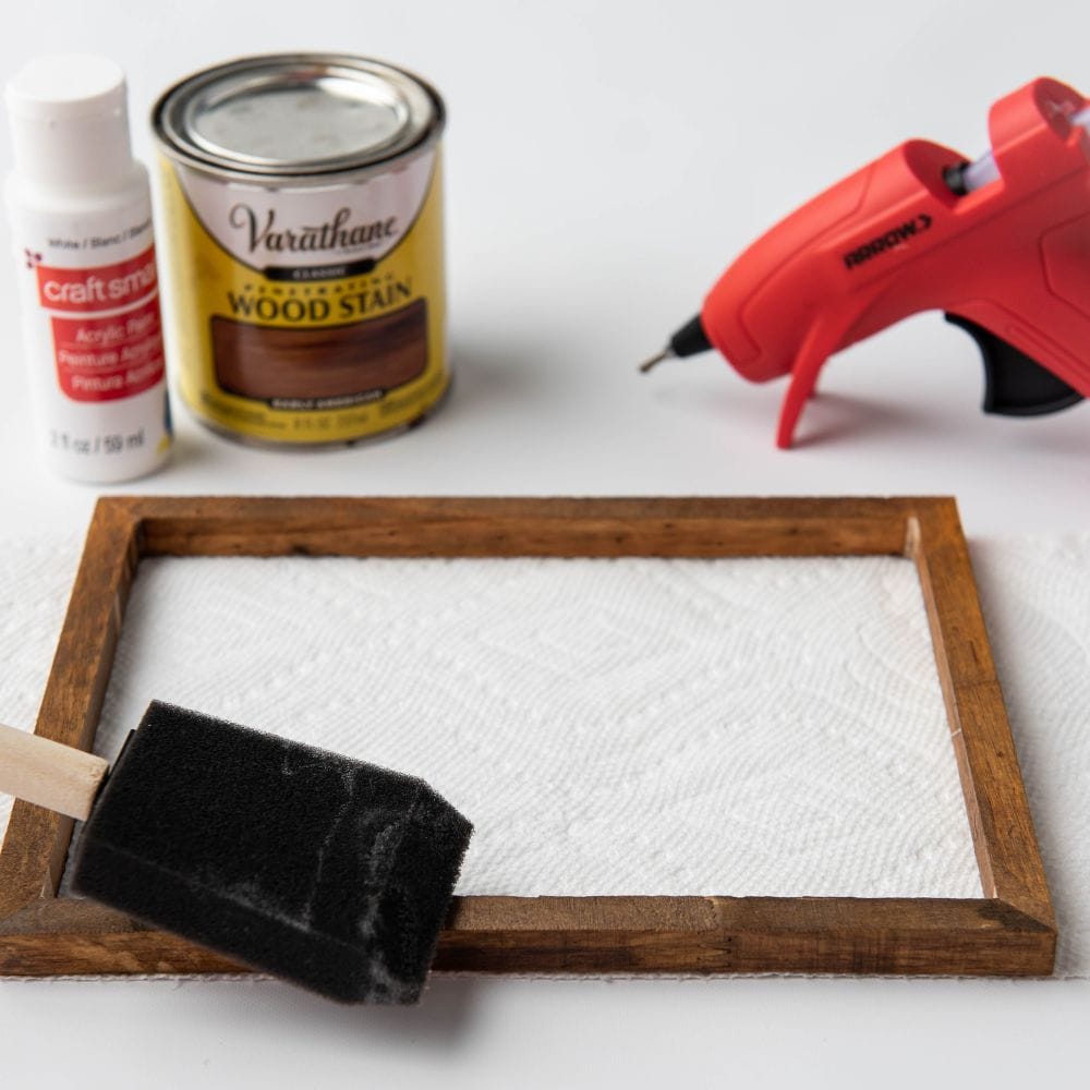 photo of applying wood stain onto frame with a sponge brush