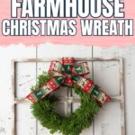 Green Christmas wreath with red and green bow on a rustic wood window frame against a white wall.