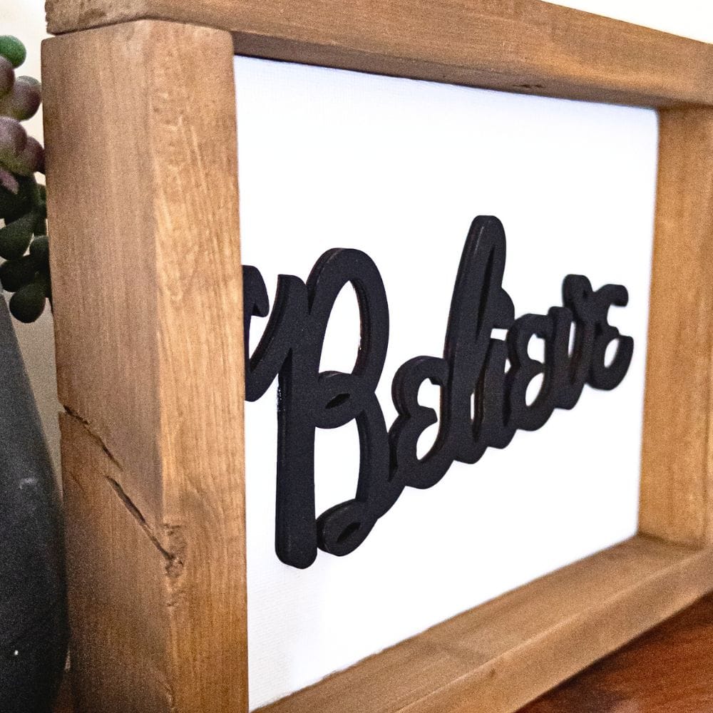 close up view of stained frame and painted laser cut believe word