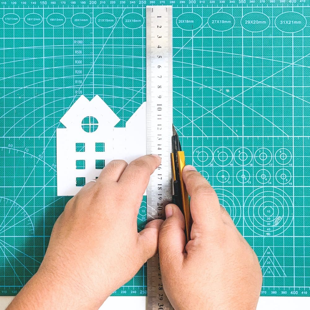 cutting out house templates with a craft cutter and a metal ruler