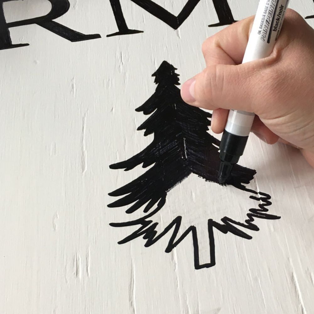 Drawing on a Christmas sign with a marker