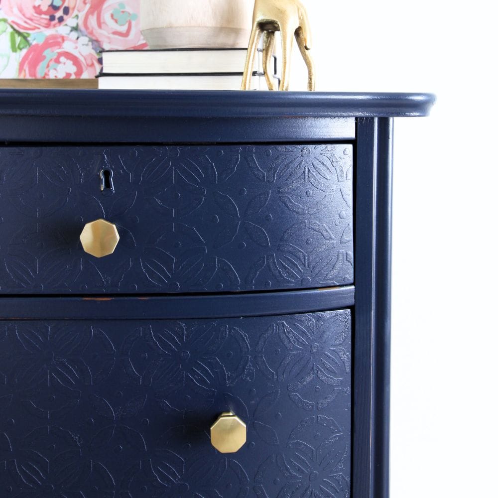 close-up view of navy blue chest of drawers showing texture and new hardware