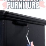 A hand painting black particle board furniture with a roller, text reads How to Paint Particle Board Furniture.