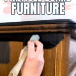 Hand painting black paint on brown particle board furniture