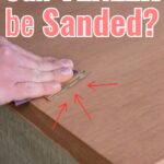 Hand sanding a wooden veneer surface with text: Can VENEER be Sanded? and red arrows pointing to the veneer.