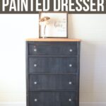 A navy blue painted dresser with four drawers, wood top