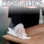 Person wearing gloves wipes a wooden surface; text says How to change wood color without sanding.