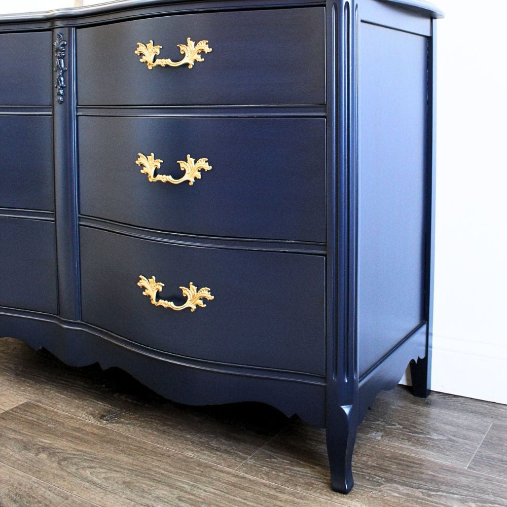 close-up photo of navy blue bedroom dresser with gold hardware after the makeover