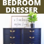 Navy blue dresser with gold handles, plant, and framed quote on top; text reads Navy Blue Bedroom Dresser.