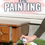 A person sprays primer on a wooden table outdoors with text: Priming wood for painting.
