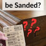 A hand holds sandpaper near wood veneer, with text asking, Can Veneer be Sanded? and red question marks.