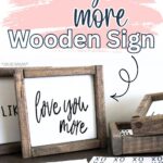 Framed wooden sign with “love you more” text, surrounded by printed cards with handwritten words and phrases.