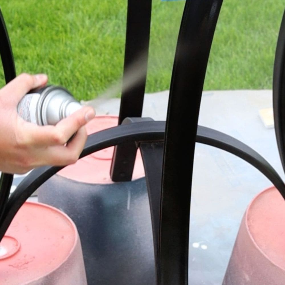 photo of spraying spray paint onto metal furniture