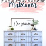 A light blue French provincial dresser with gold handles, decor, and a sign reading I love you more on top.