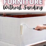 Hand using paint roller on white particle board furniture; text reads: How to Paint Particle Board Furniture Without Sanding.