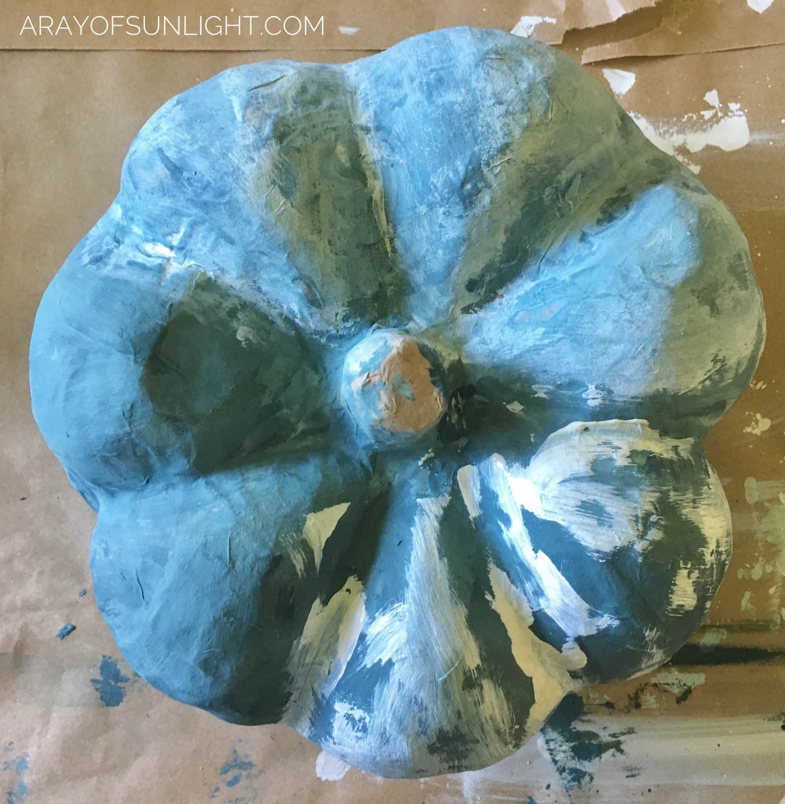 painting a paper mache pumpkin with blue and white chalk paint