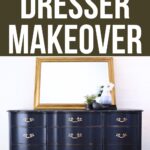 Midnight blue dresser with gold handles, styled with a gold-framed mirror, plant, and vase on top.