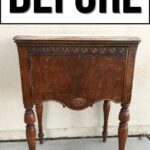 A small, ornate wooden side table with visible wear