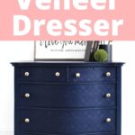 Navy blue dresser with gold knobs under a sign reading Painting a Veneer Dresser.