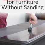 Person painting black paint on a dark wooden dresser, text reads Best Black Paint for Furniture Without Sanding.