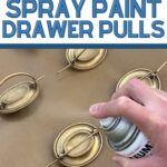 Hand spray painting gold drawer pulls on a brown surface; text reads How to Spray Paint Drawer Pulls.