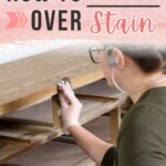Person wearing gloves and mask applies wood stain to a dresser