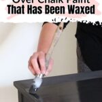 A person paints a black table surface with a brush. Text reads: How to paint over chalk paint that has been waxed.
