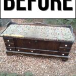 Old wooden bench with worn, patterned fabric seat, outdoors on gravel, text BEFORE above.