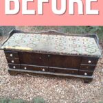 Old wooden chest with a worn, patterned cushion, sitting outdoors on gravel, with “BEFORE” text above.