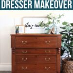 Refinished four-drawer antique wooden dresser with brass handles, topped with plants and decor, on a patterned rug.