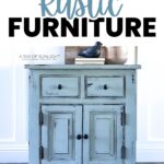 Blue rustic cabinet with black knobs underneath books, a bird decor, and wall art