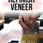 Hand using a paintbrush to refinish a wooden surface, with text “How to Refinish Veneer” above.