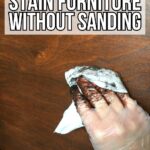Gloved hand wiping dark stain on wood with text: How to Stain Furniture Without Sanding.