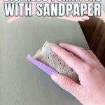 A hand sanding a piece of furniture with sandpaper under the text How to Distress Furniture With Sandpaper.