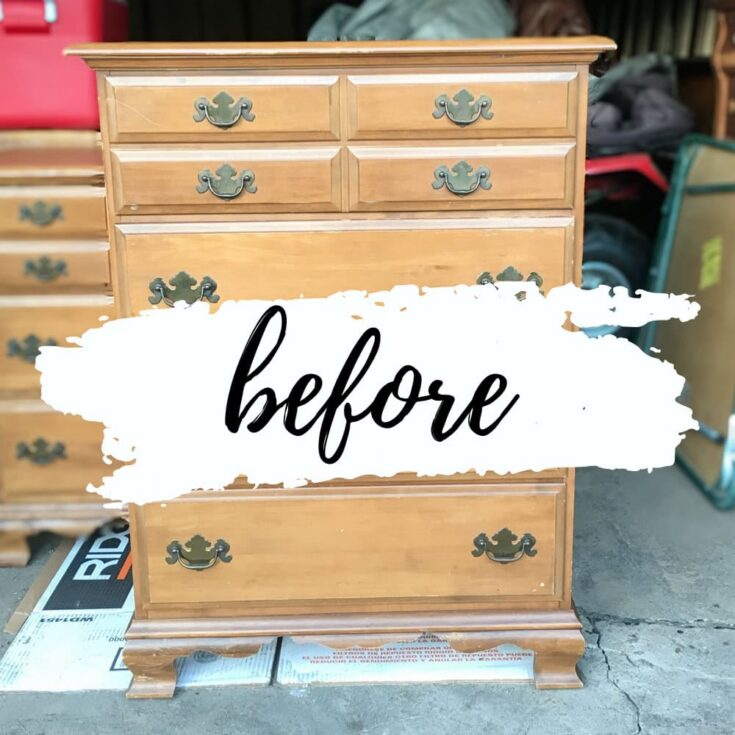 A wooden dresser with ornate handles; sitting in a garage