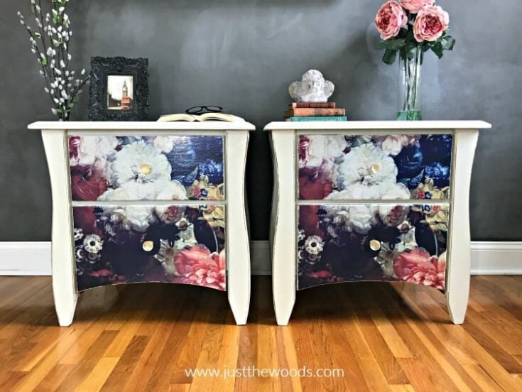 Two white nightstands with colorful floral drawers, topped with books, decor, and pink flowers
