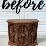 A vintage wooden cabinet sits on a driveway with the word before written above it in script.