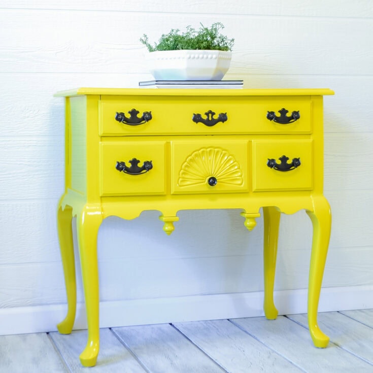 A bright yellow vintage table with black handles