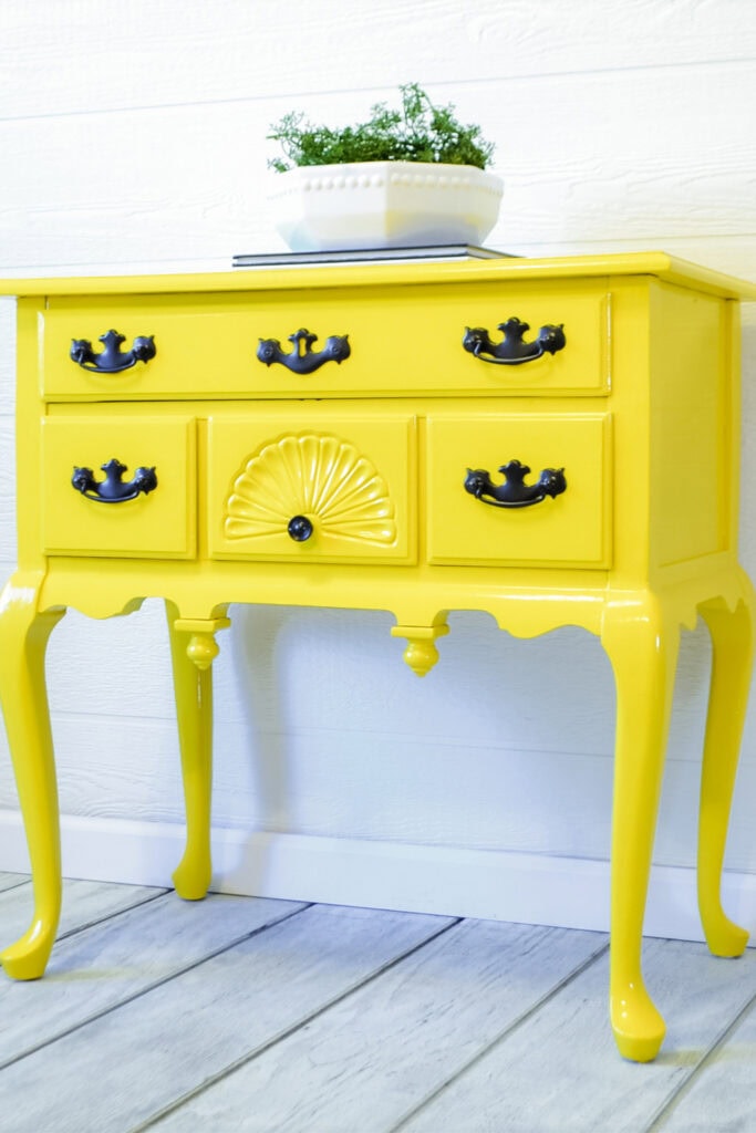 Glossy yellow vintage table with black hardware